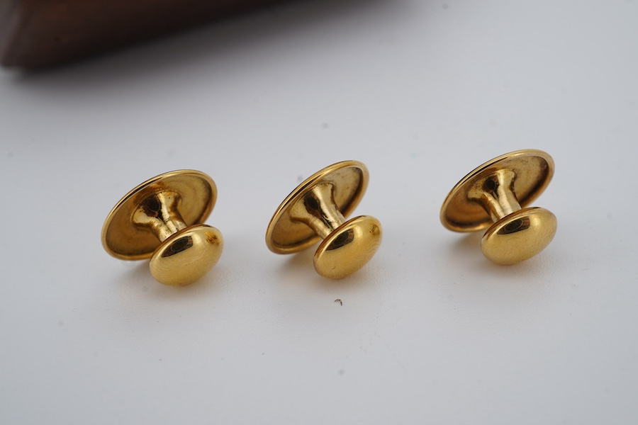 A set of three gold dress studs, each of circular outline in polished gold, approximately 7mm diameter each, each marked 18ct, combined gross weight 3 grams, fitted case
